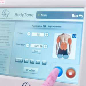 Provider adjusts BodyTone settings before beginning loose skin treatment in Farmington, NM
